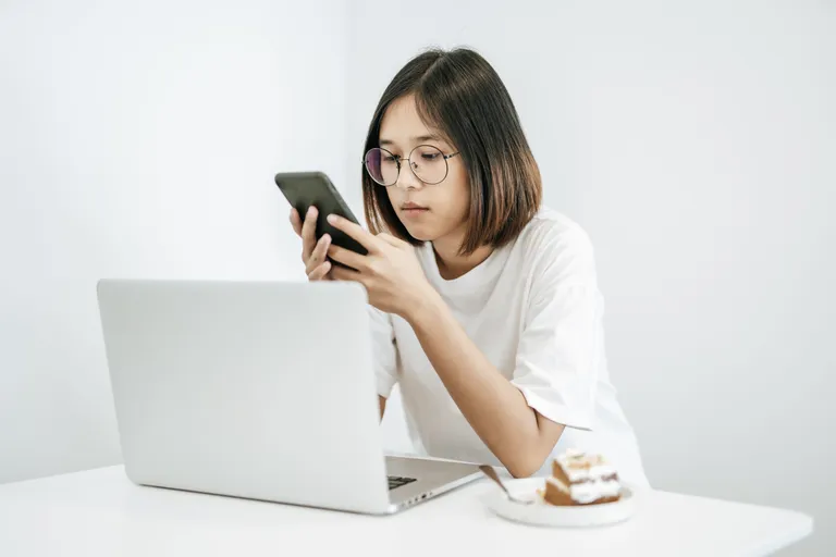 woman-wearing-white-shirt-playing-smartphone