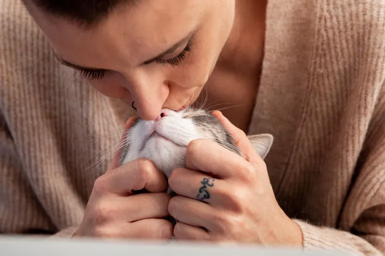 woman-holding-her-adorable-kitty-home