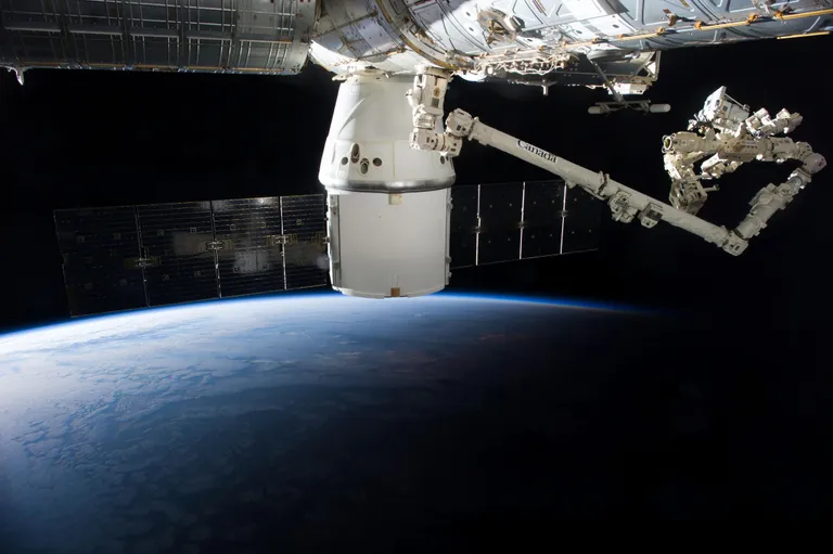 ภาพถ่ายแขนกล Canadarm 2 กำลังดึงอุปกรณ์วิทยาศาสตร์ ISS-RapidScat ออกจาก Trunk ของยาน Dragon ในภารกิจ CRS-4 ที่มา NASA