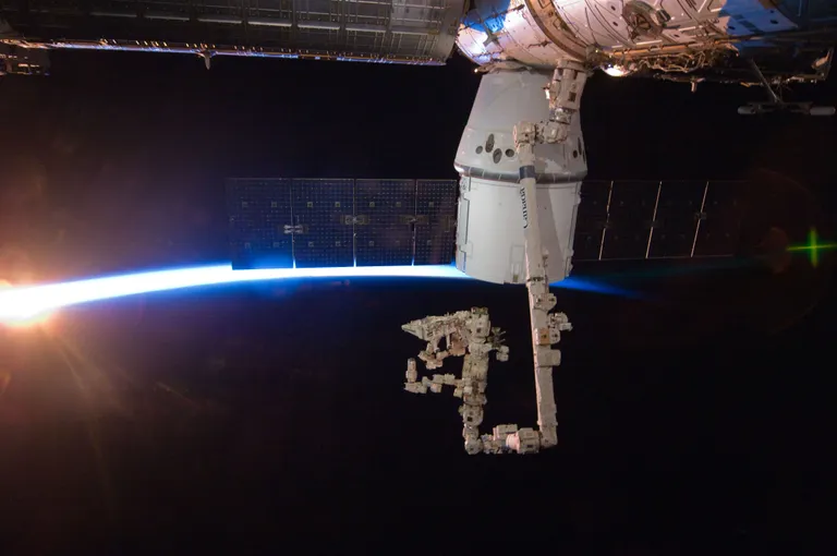 ภาพถ่ายยาน Dragon ในภารกิจ CRS-1 เทียบท่าเชื่อมต่อสถานีอวกาศนานาชาติด้วยแขนกล Canadarm 2 ที่มา NASA