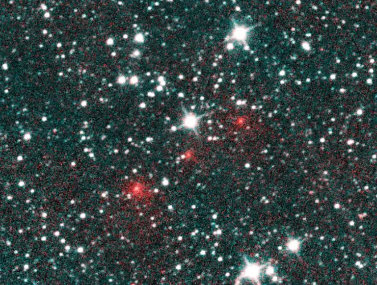 ภาพถ่ายจุดสีแดงกลางภาพแสดงให้เห็นถึงดาวหาง NEOWISE ที่กำลังเคลื่อนตัวผ่านอวกาศฉากหลัง ซึ่งภายหลังได้มีการยืนยันว่าเป็นดาวหางคาบยาวที่เดินทางมาจากอวกาศลึกที่ห่างไกล