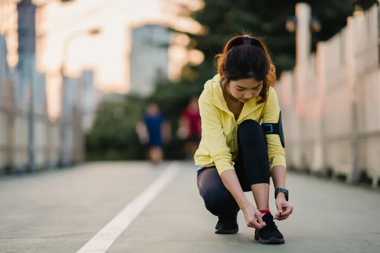 young-asia-athlete-lady-exercises-tying-laces-work-out-urban-environment-japanese-teen-girl-wearing-sport-clothes-walkway-bridge-early-morning-lifestyle-active-sporty-city