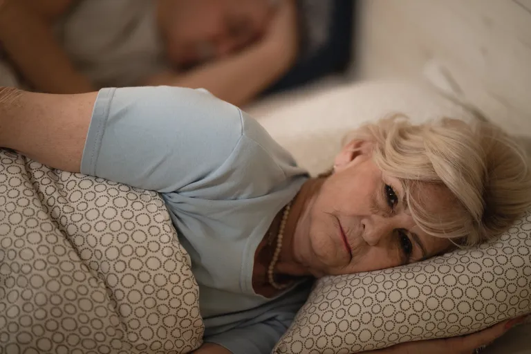 senior-woman-thinking-while-lying-bed-awake-late-night