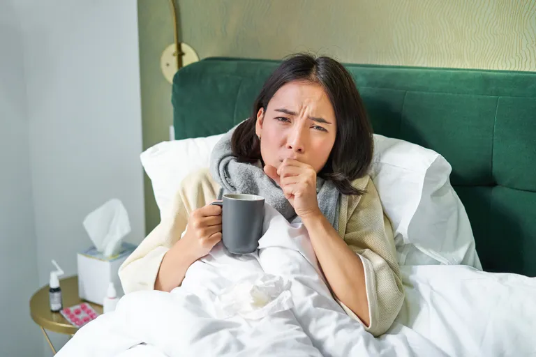 portrait-couching-asian-girl-bed-feeling-sick