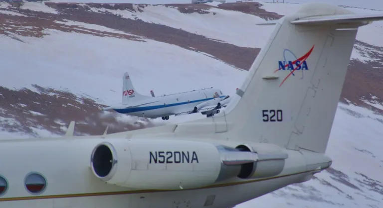ภาพเครื่องบิน P-3 Orion บินขึ้นจากฐานบินโดยมีเครื่อง Gulfstream III เป็นฉากหน้า