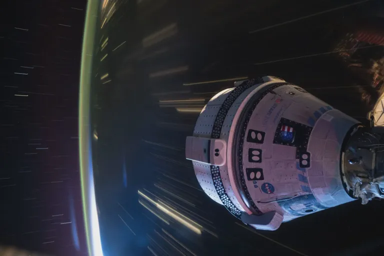 ภาพถ่ายของยาน Boeing Starliner ที่เชื่อมต่อกับสถานีอวกาศนานาชาติขณะโคจรผ่านช่วงกลางคืนของวงโคจรรอบโลก