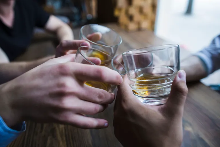 hands-toasting-whisky-glasses