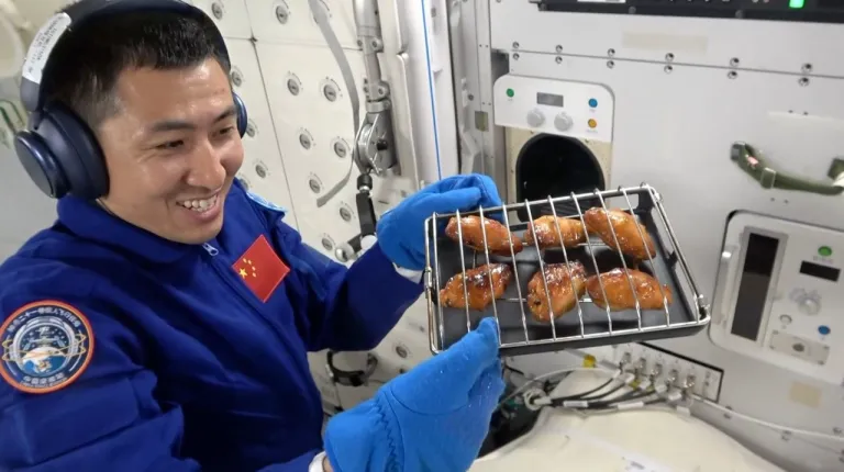 ภาพถ่ายนักบินอวกาศนำถาดไก่อบออกมาจากเตาอบโดยไก่อบออกมาหน้าตาน่ารับประทาน ภาพจาก CMS