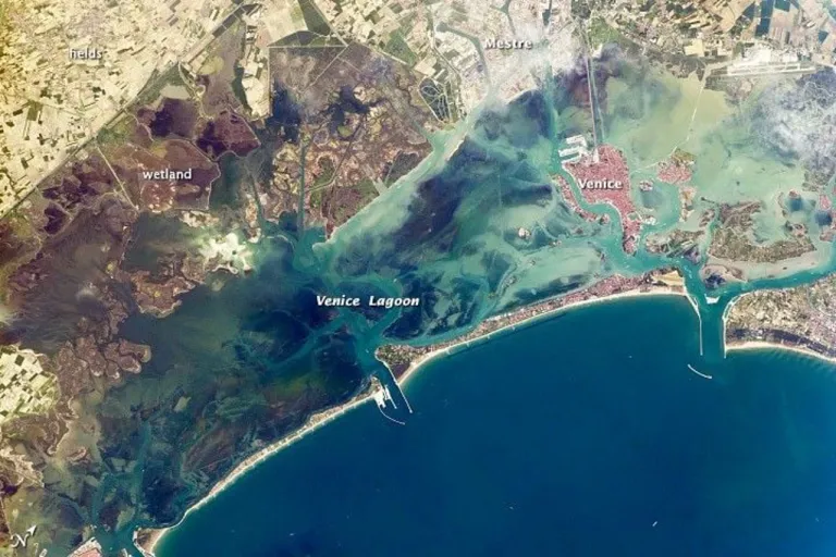 ภาพถ่ายทะเลสาบเวนิสที่ถ่ายโดยลูกเรือภารกิจ Expedition 39 บนสถานีอวกาศนานาชาติ (ISS) ในปี 2014 จะเห็นเกาะกำบังและอ่าวเล็ก ๆ บริเวณขอบล่างของทะเลสาบ ภาพจาก NASA Earth Observatory