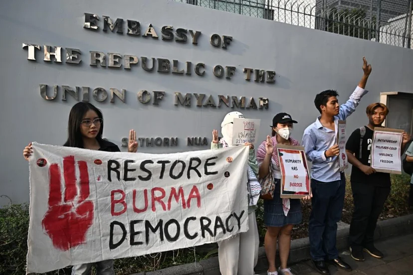 นักกิจกรรมชาวไทยถือป้ายประท้วงระหว่างการประท้วงเนื่องในโอกาสวันครบรอบ 4 ปีรัฐประหารเมียนมา ณ สถานทูตเมียนมาประจำประเทศไทย กรุงเทพฯ เมื่อวันที่ 1 กุมภาพันธ์ 2568 (AFP / Lillian SUWANRUMPHA)