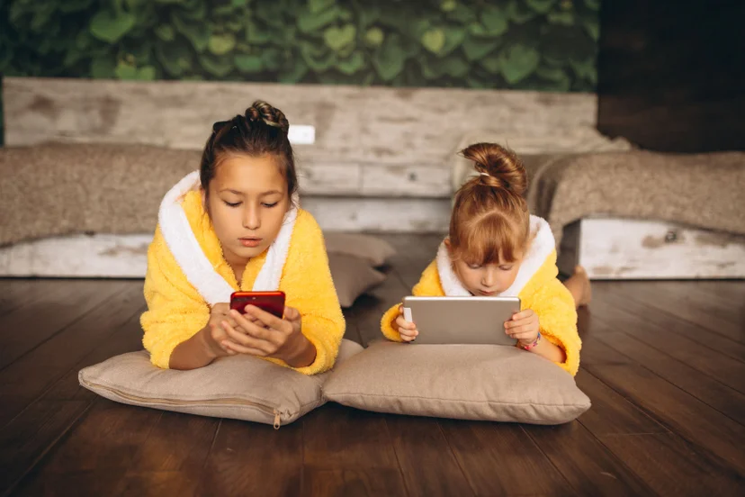 sisters-lying-floor-with-phone-tablet