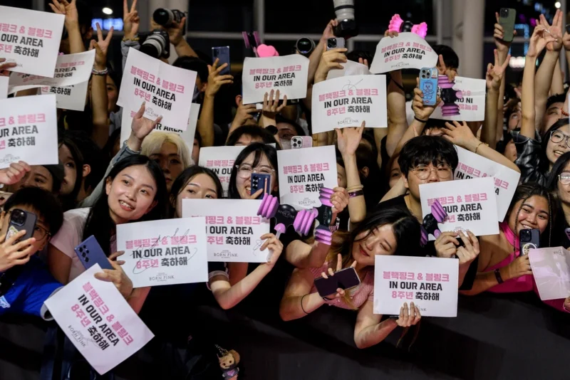 แฟนคลับถือป้ายสนับสนุนเกิร์ลกรุ๊ปเคป็อป BLACKPINK