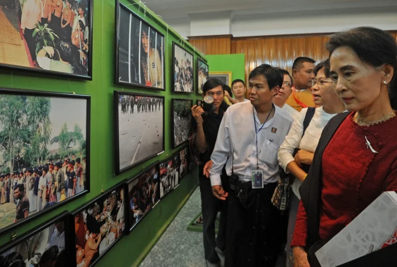 อองซานซูจี ขณะที่เดินชมนิทรรศการครบรอบ 25 ปีการลุกฮือ 8888 ที่ย่างกุ้ง (ภาพจาก: Soe Than Win/AFP)