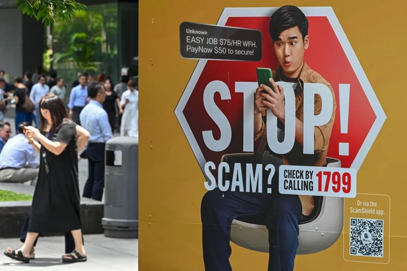 A poster warning of scam threats in Singapore&rsquo;s Raffles Place district (Photo: Roslan Rahman/AFP)