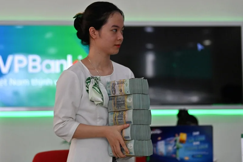 พนักงานธนาคาร VPBank สาขาหนึ่งในฮานอยกำลังขนเงินสด (ภาพจาก Nhac Nguyen/AFP)