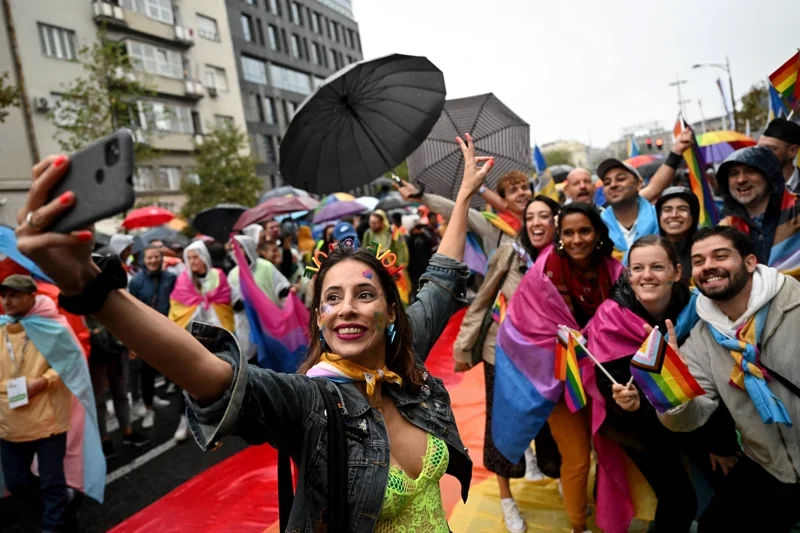 ผู้ร่วมงาน EuroPride 2022 ณ กรุงเบลเกรดกำลังถ่ายรูปเซลฟี (ภาพจาก: Andrej Isakovic/AFP)