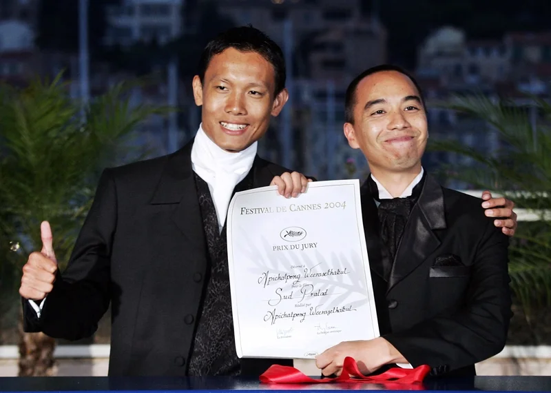 อภิชาติพงศ์ (ขวา) และศักดิ์ดา แก้วบัวดี นักแสดง โชว์ผลประกาศรางวัล Prix de Jury ที่ 'สัตว์ประหลาด' ได้รับในเทศกาลหนังเมืองคานส์ปี 2004 (ภาพจาก: Pascal Guyot/AFP)